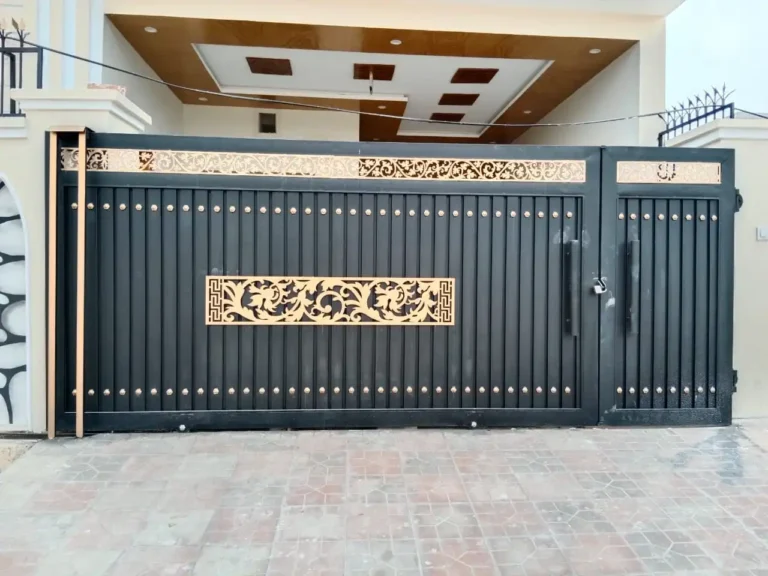 Black steel main gate with a gold pattern panel